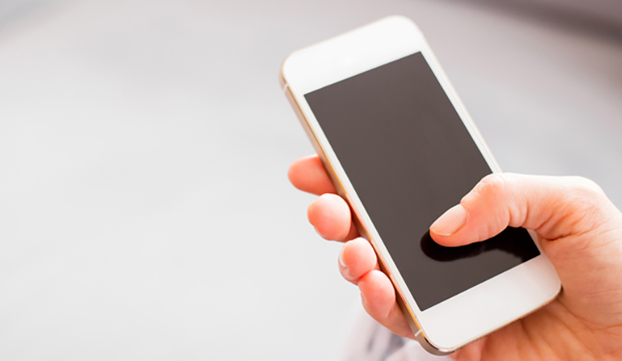 A close up of someone holding their rose gold iPhone so that you can see the screen is turned off