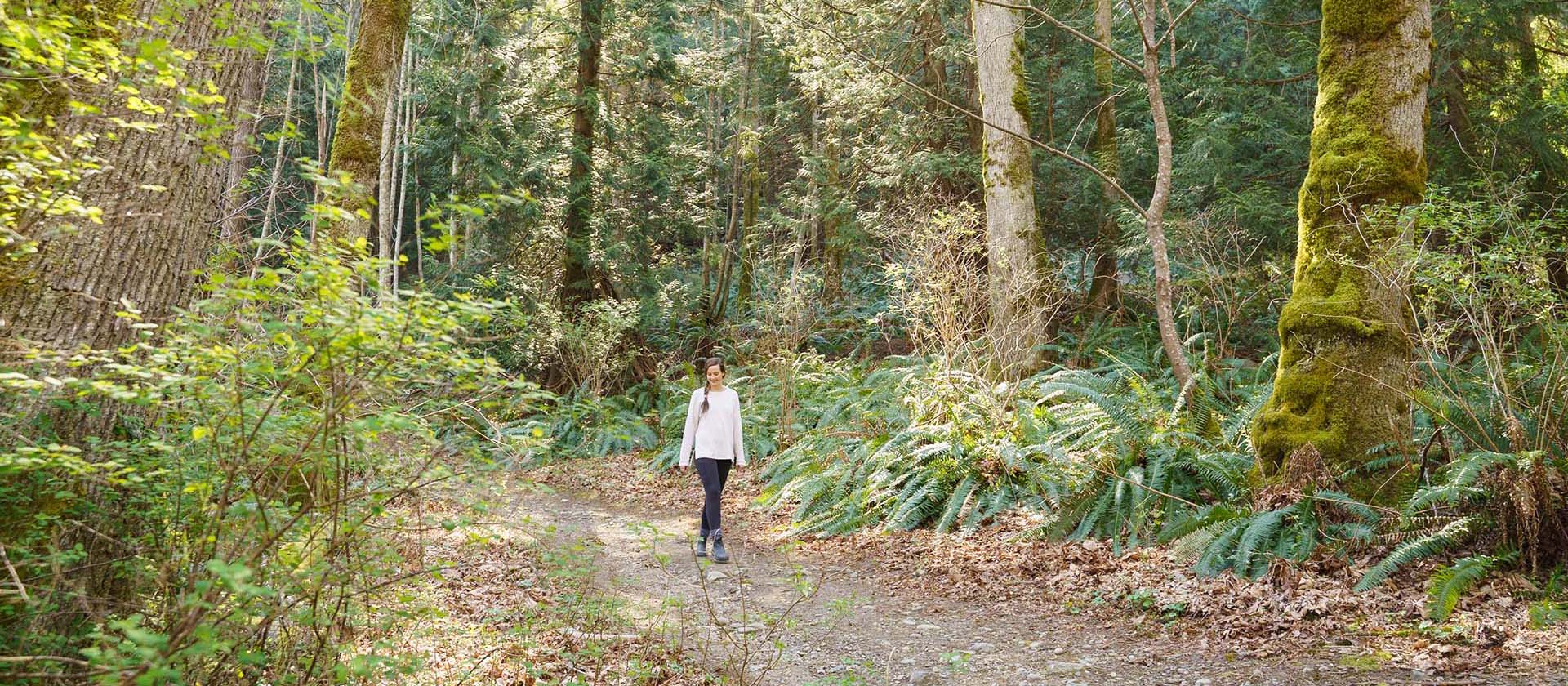 Woman walking along forest path