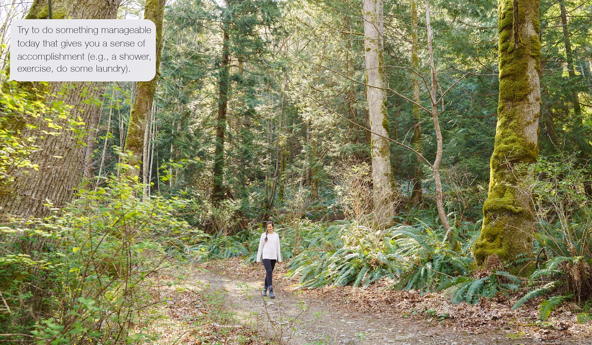 Woman walking along forest path.