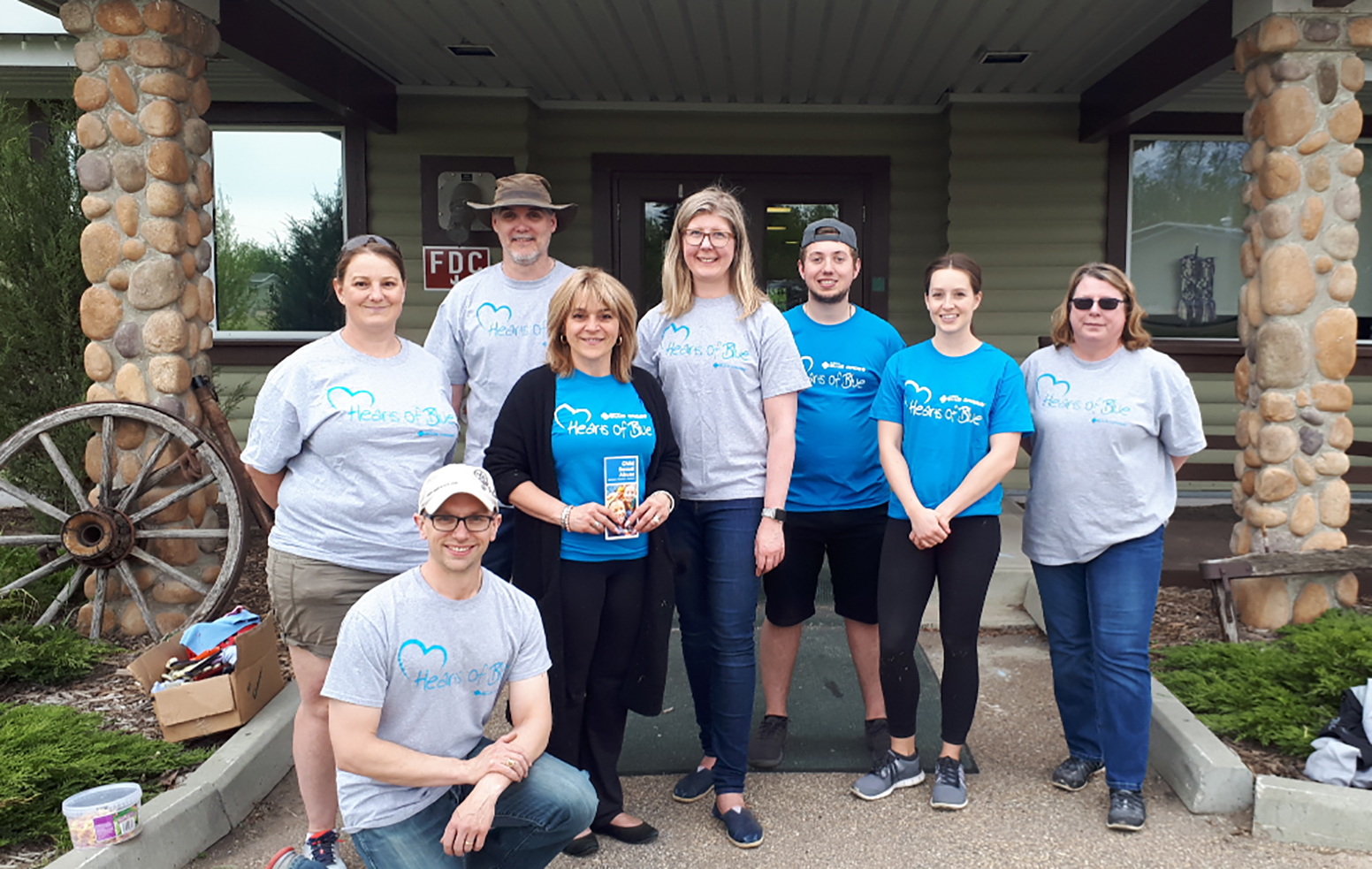 Team members standing together in front of building for community event.