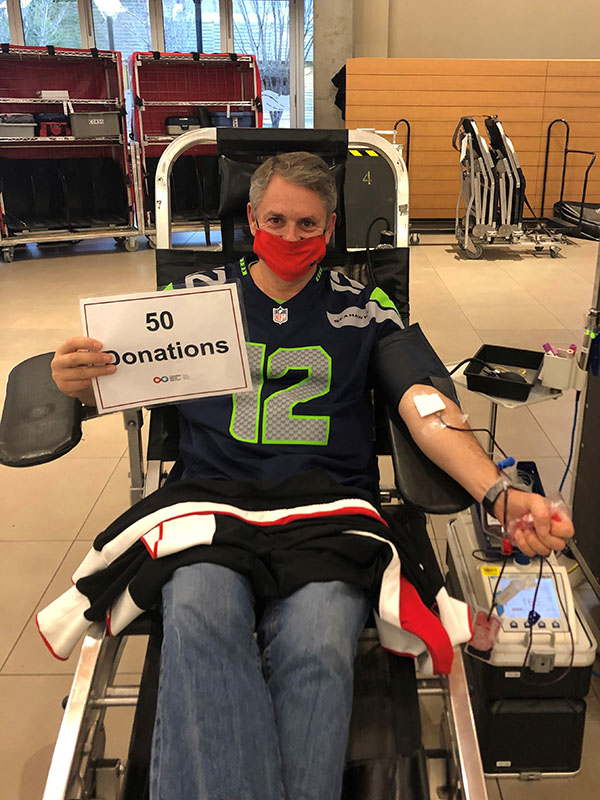 Kurt George holding up a sign that says 50 donations