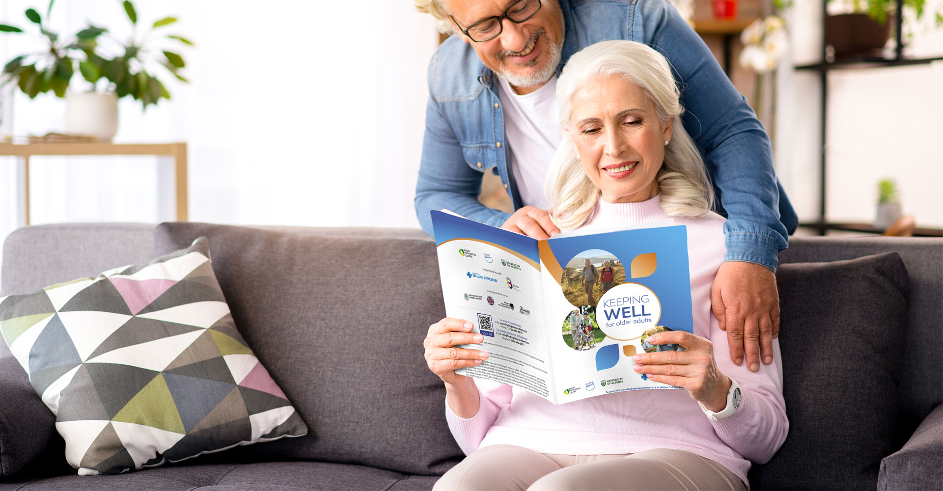 A older Albertan couple is reading Keeping Well together.