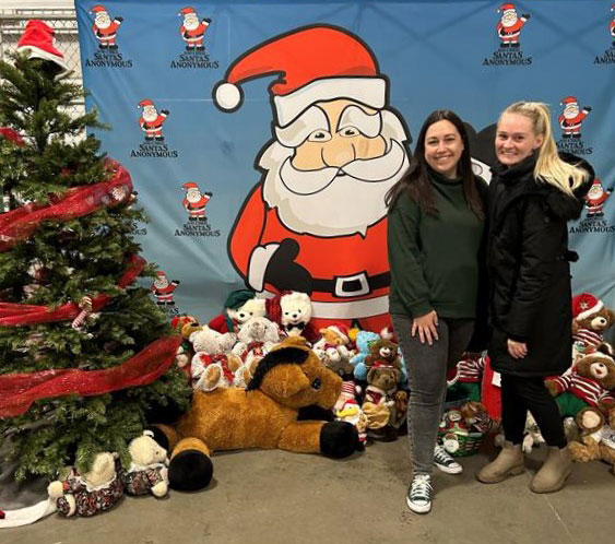 Alberta Blue Cross® team members standing beside toys donated to Santas Anonymous.