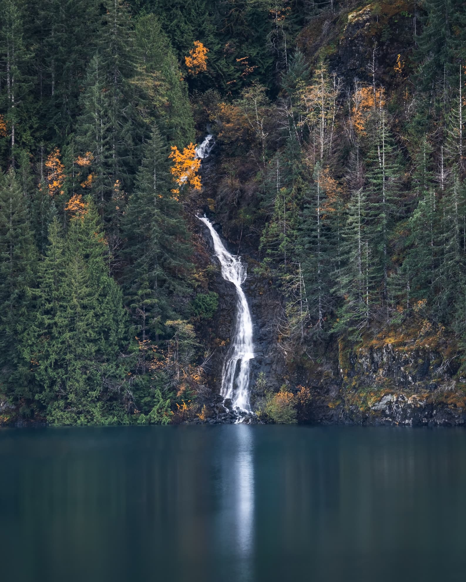 A waterfall flowing from a cliff to a body of water.